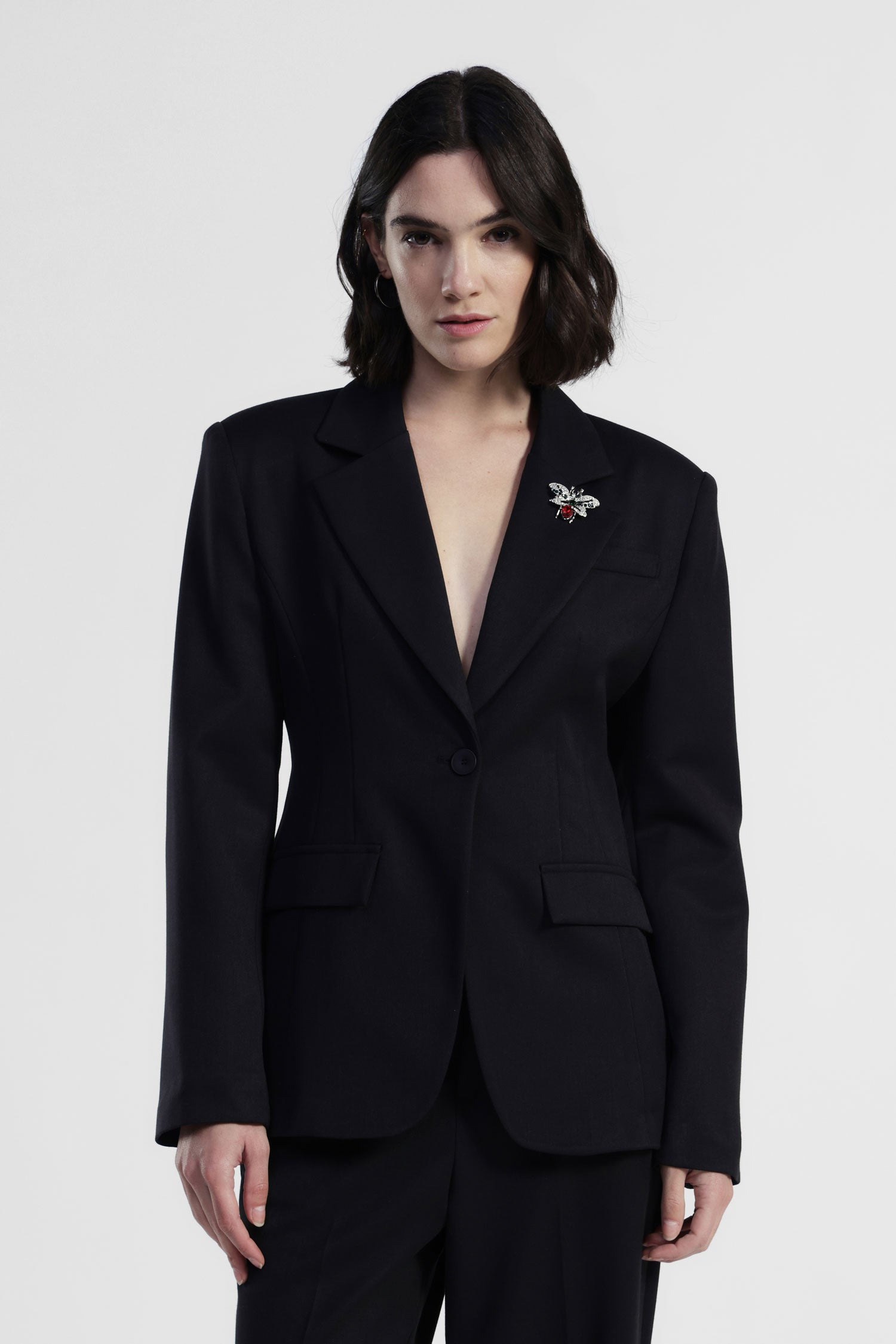 Blazer monopetto con spilla decorativa e tasche